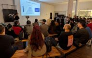 Claudia Badell presentando ideas clave del libro Agile Testing Condensed en la meetup de UruQAy, junto a la audiencia.